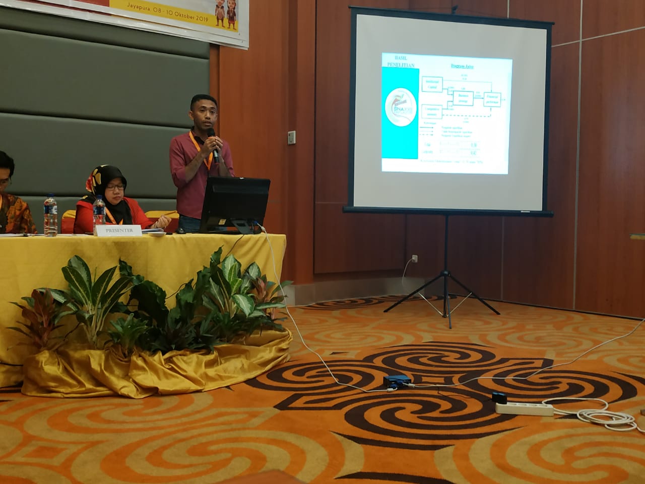 Longginus Gelatan Presentasikan Tesis Dalam Simposium Nasional Akuntansi 2019 di Papua